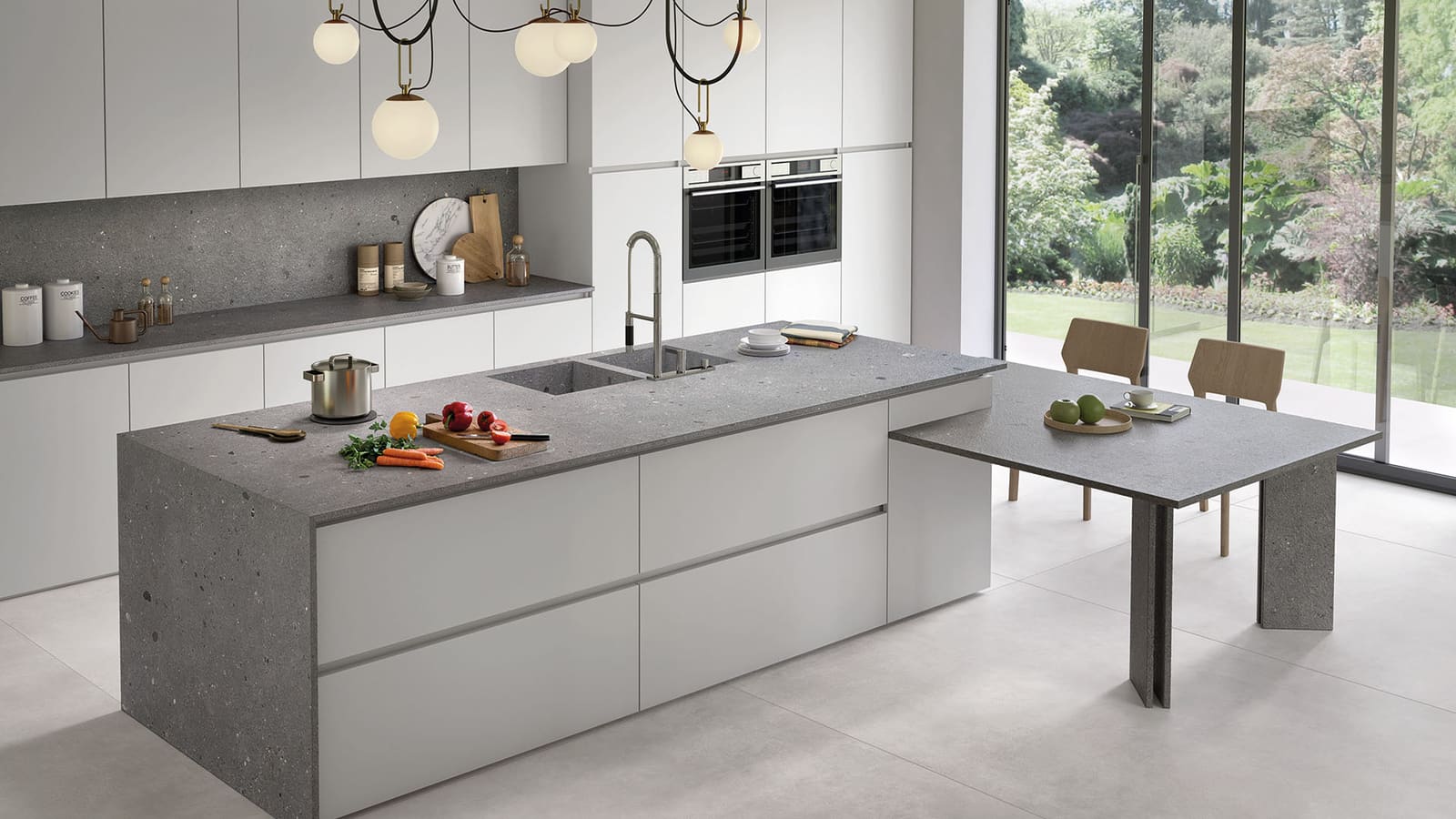A finished kitchen with stone island and full-height backsplash